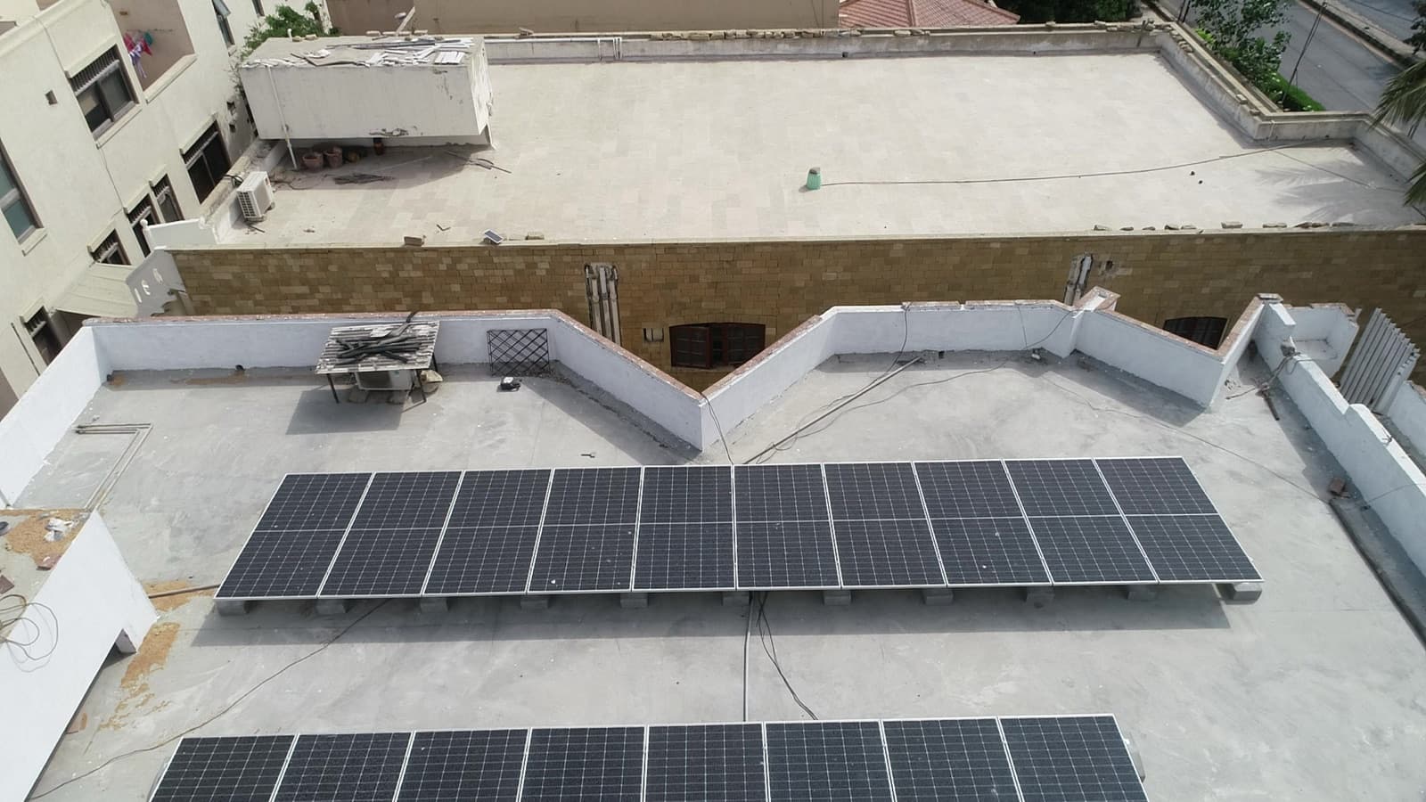 Ballasted solar panel rows on a flat residential roof